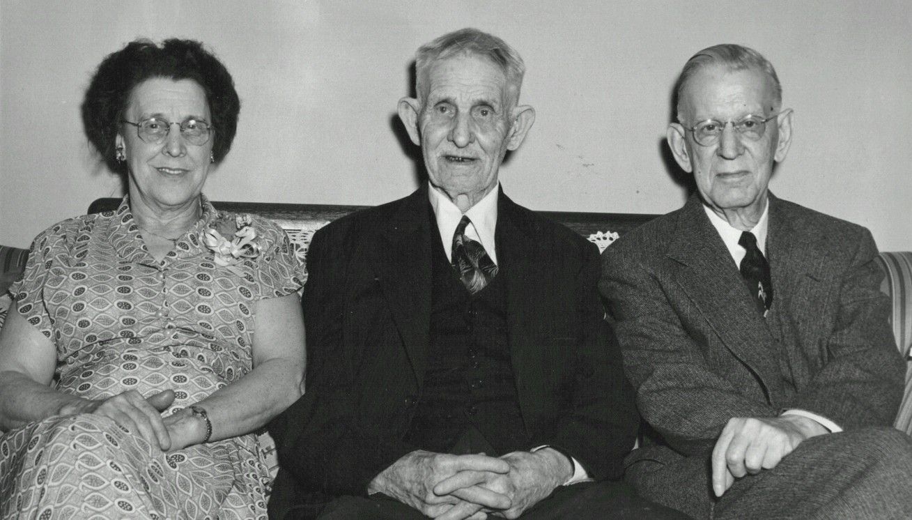 Three people sitting on a couch.