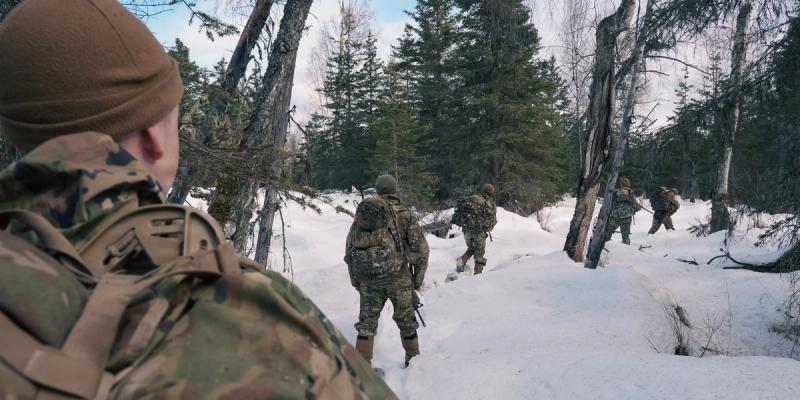  A U.S. Army soldier assigned to the Multi-Functional Reconnaissance Company, 2nd Infantry Brigade Combat Team (Airborne), 11th Airborne Division, maneuver through the woods during Operation Arctic Tech at Joint Base Elmendorf-Richardson, Alaska, April 8, 2026.