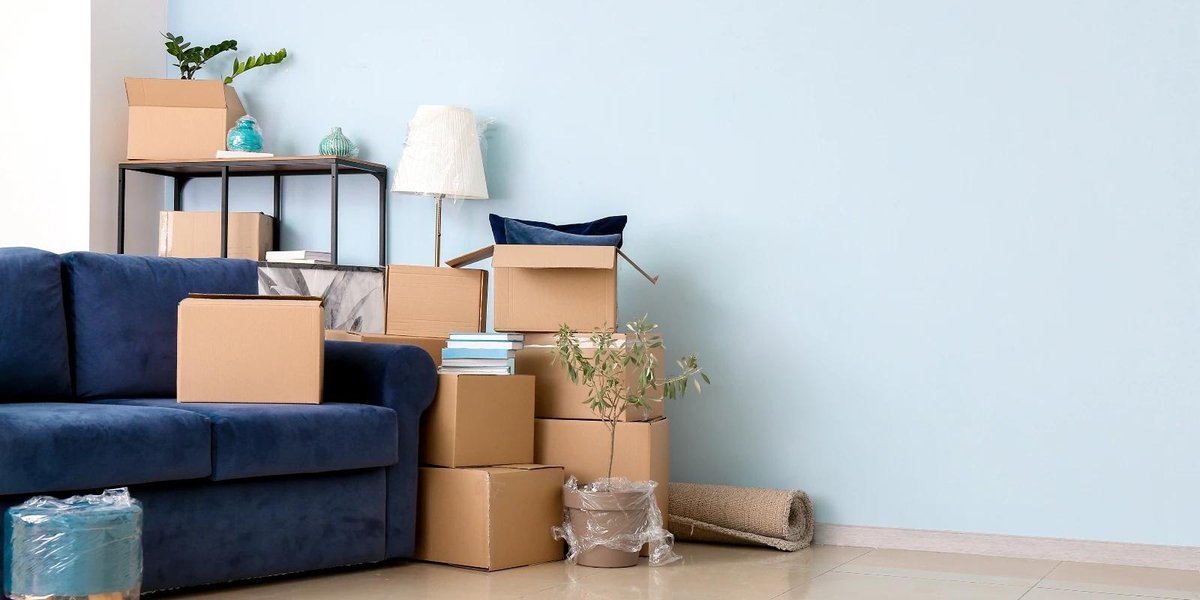 Moving boxes and packed items in a living room for military overseas relocation.