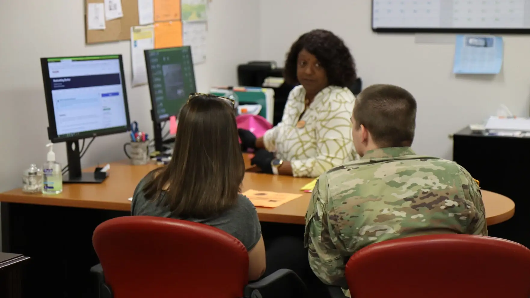A couple consults with a family support specialist in an office.