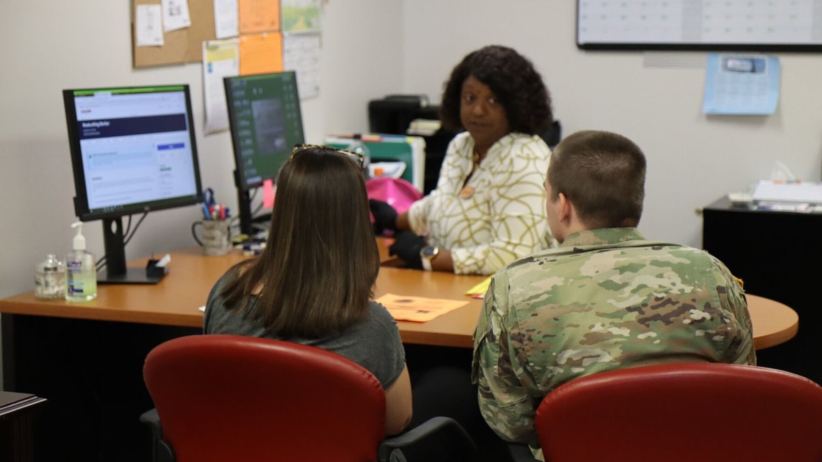 A couple consults with a family support specialist in an office.