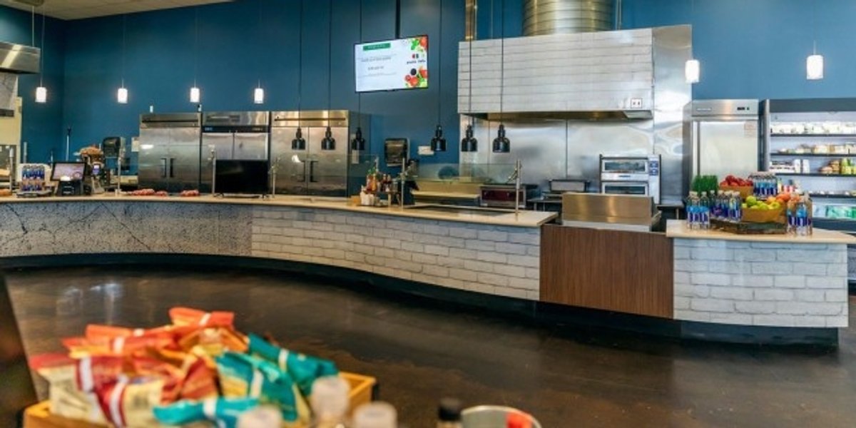 A brand new, empty service counter and kitchen in a military cafeteria.