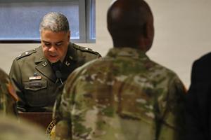 Senior officer speaks soldiers standing attention.