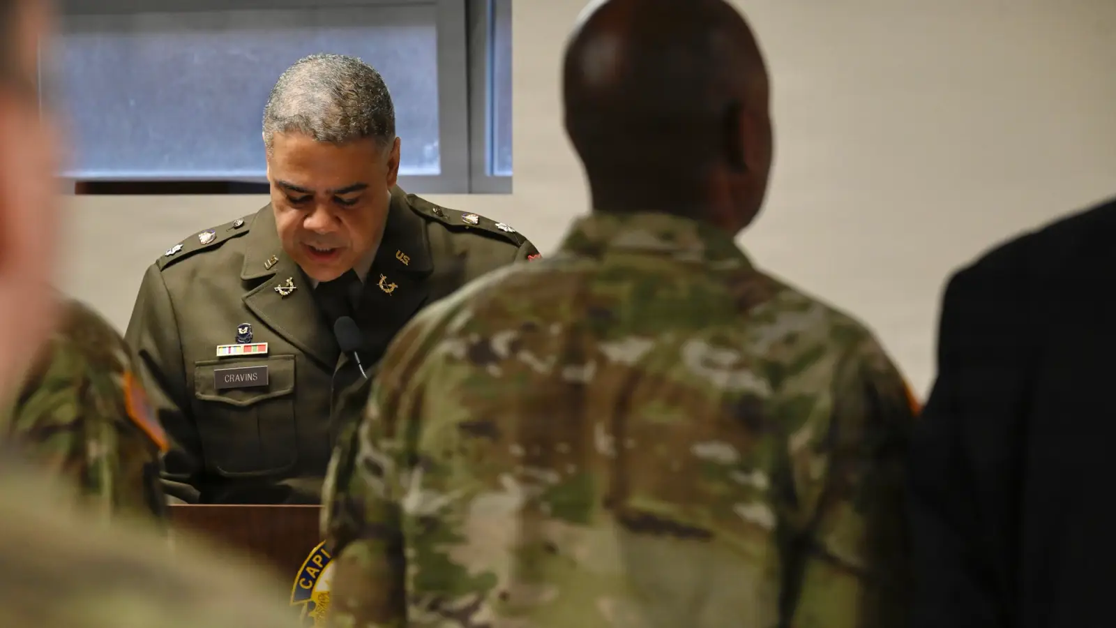 Senior officer speaks soldiers standing attention.