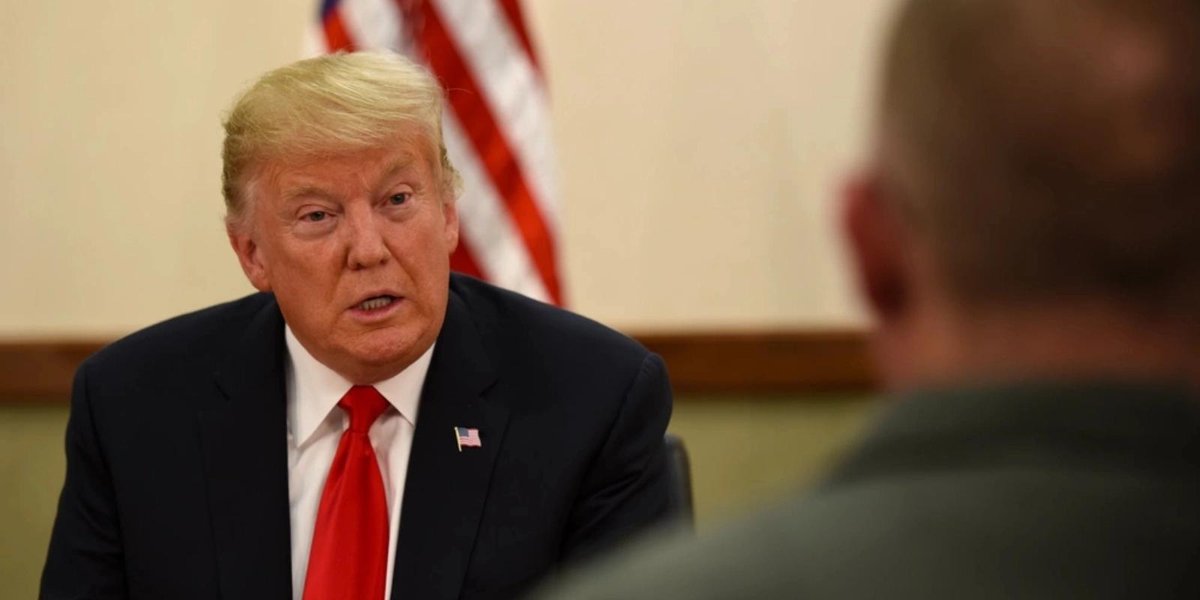 I don't know who this is, but the image shows a person in a suit with an American flag in the background.