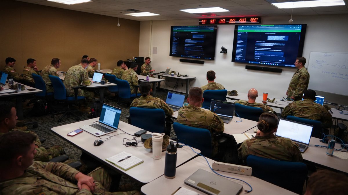 Soldiers attend a seminar on AI in a classroom with laptops.