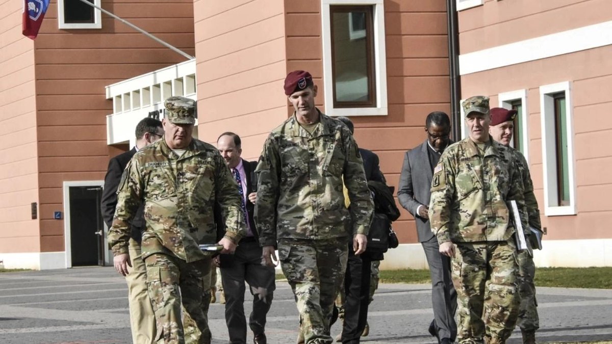 Army officers in uniform walking outside a building on a U.S. Army base in Italy