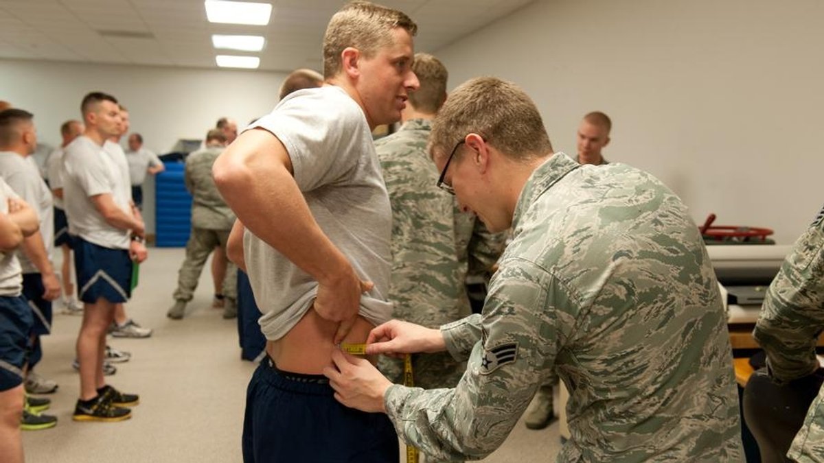 Airmen have their waists measured.