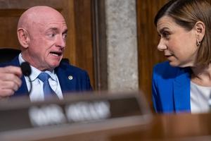 Sens. Mark Kelly (D-Ariz.) and Elissa Slotkin (D-Mich.) talk to each other in a hearing.