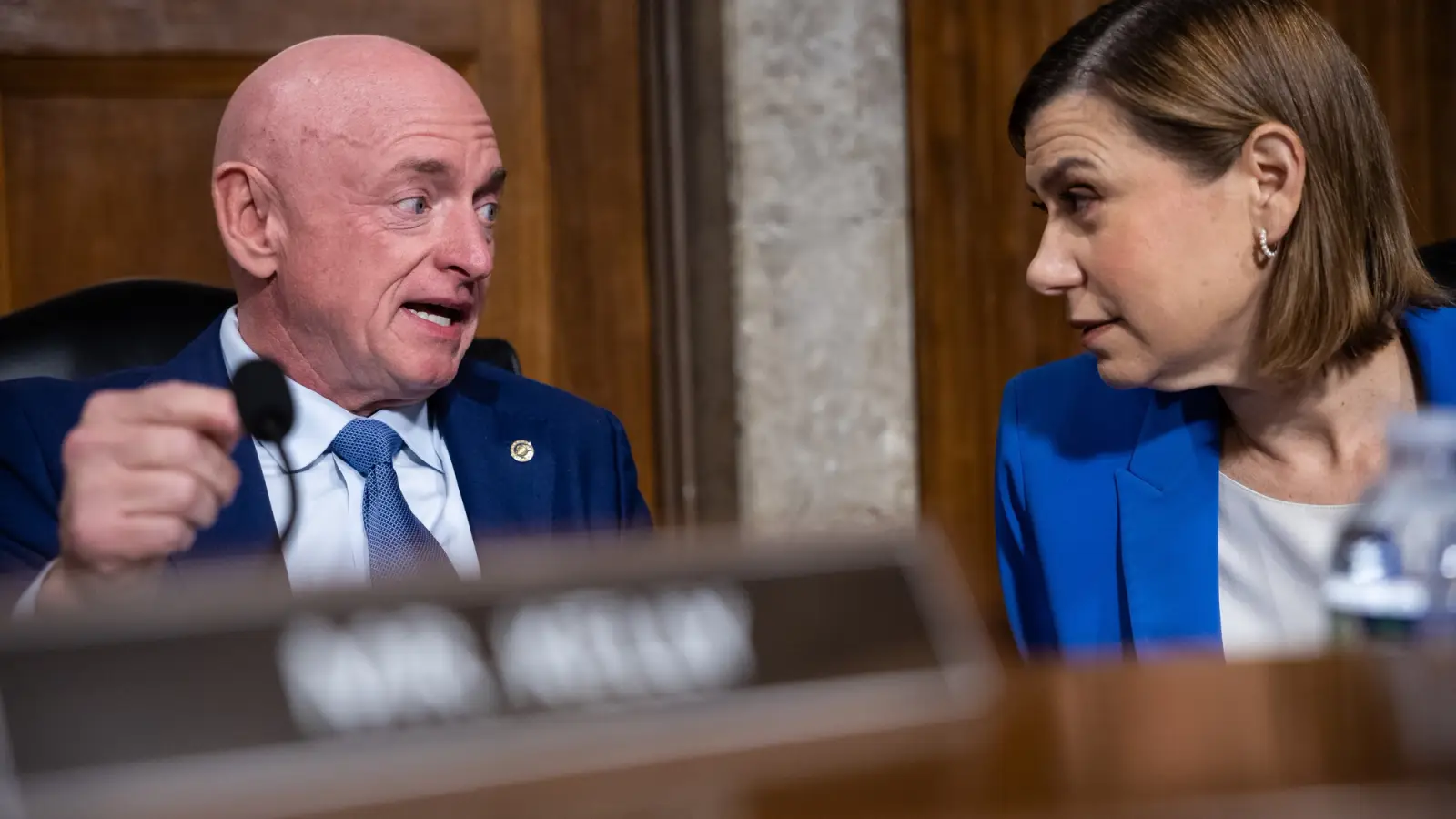 Sens. Mark Kelly (D-Ariz.) and Elissa Slotkin (D-Mich.) talk to each other in a hearing.