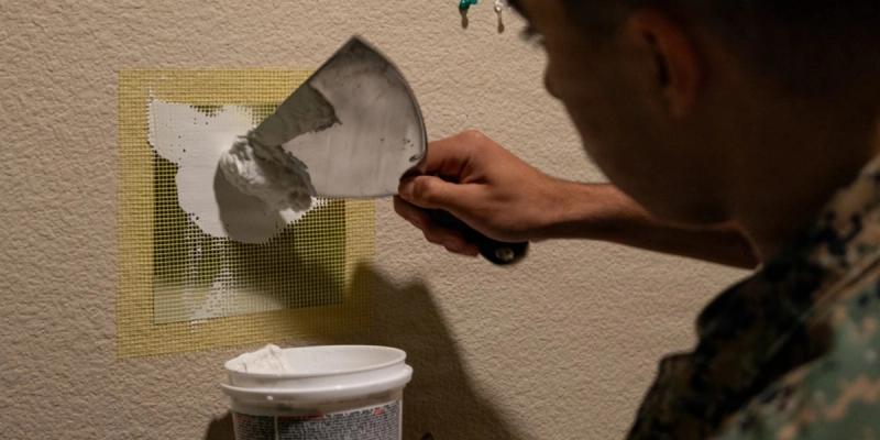 U.S. Marine Corps Pfc. Marcos LopezContreras, an inventory management specialist with 1st Combat Readiness Regiment, 1st Marine Logistics Group, patches a hole in dry wall during Operation Clean Sweep IV on Marine Corps Base Camp Pendleton, California, April 7, 2026.