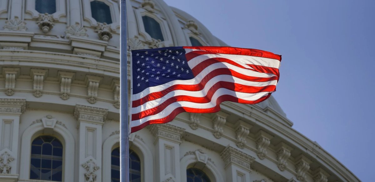 The flag of the United States waves over the Capitol dome.