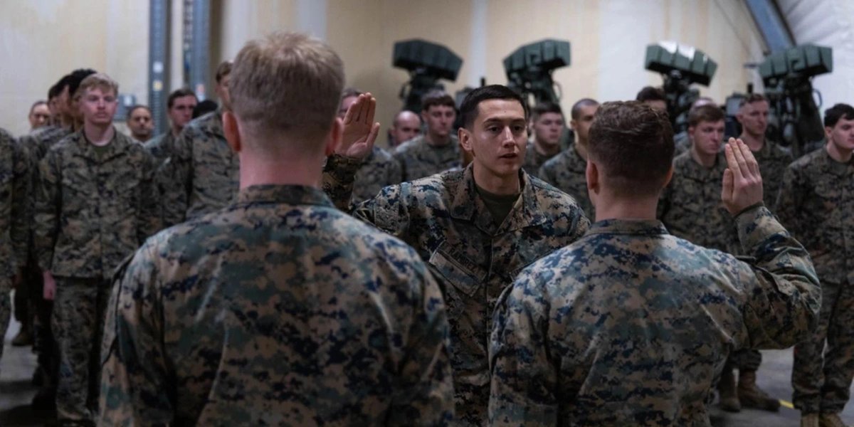 Marine Corps Marines taking reenlistment oath indoors with missile defense systems in background