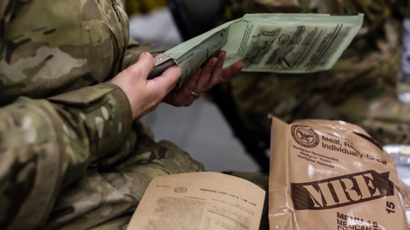 A U.S. Air Force Airman with the 24th Intelligence Squadron Eagle Vision 1 flight opens his Meal, Ready to Eat while participating in exercise Contested Forge '18 at Grostenquin Air Base, France.