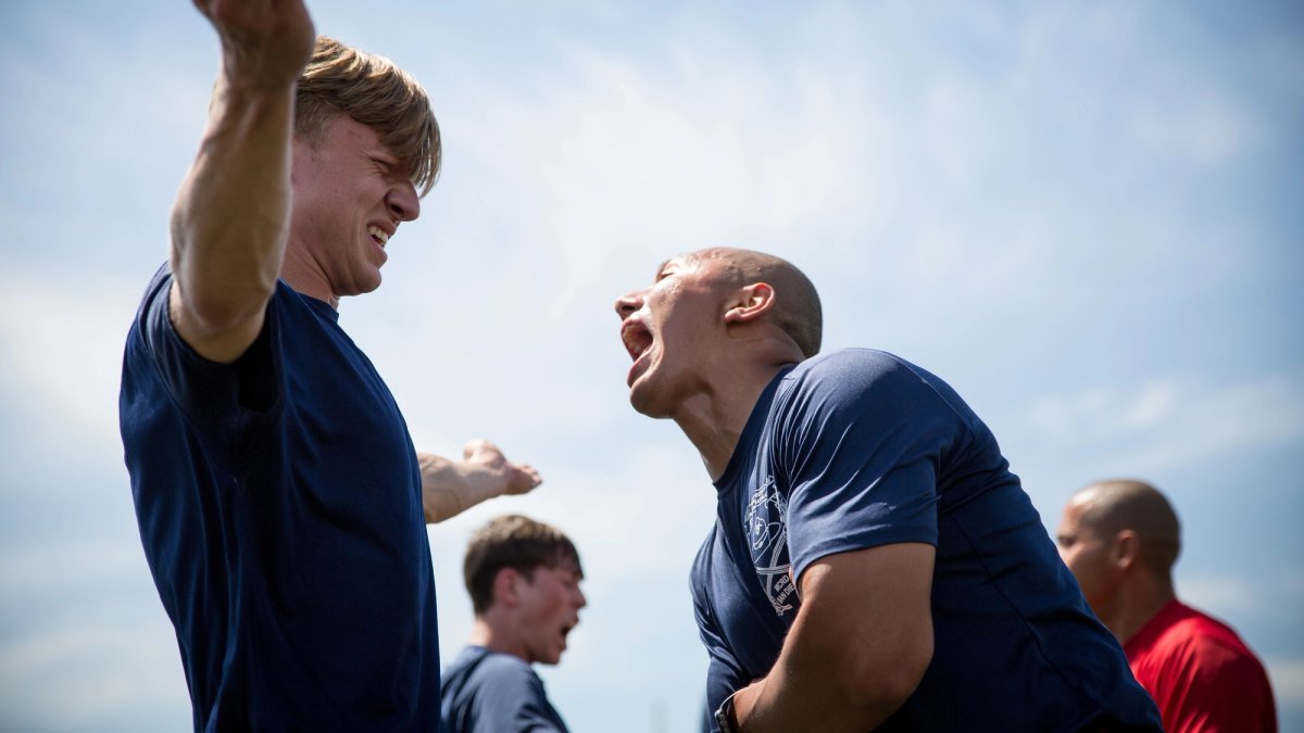 A drill sergeant yells in the face of a new recruit.