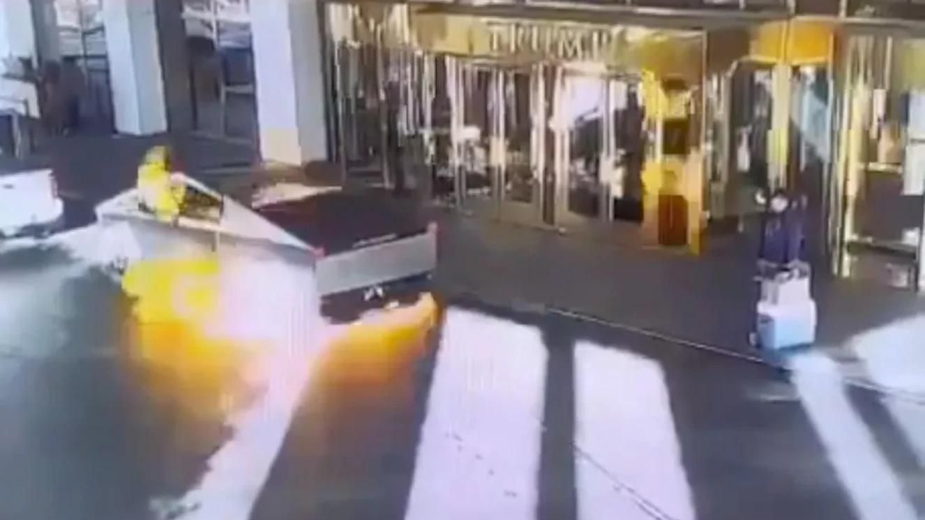 Cybertruck exploding near building entrance, leaving trail of smoke and flames.
