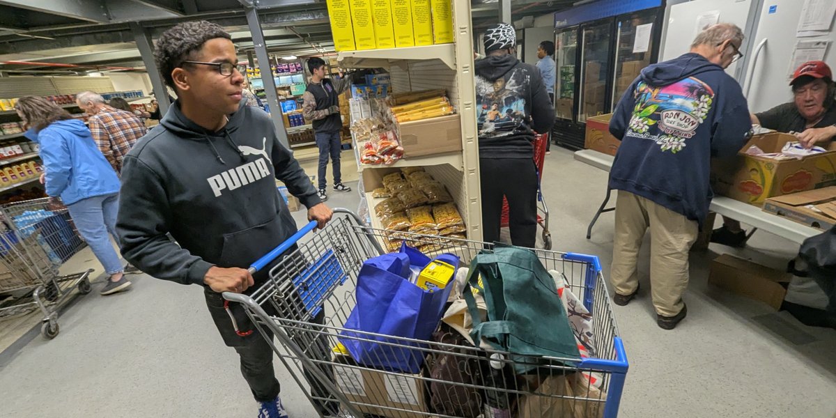 Spc. Oscar Moore helps load up a patron’s cart at the Veterans Food Pantry in Watertown.  Photo by Mike Strasser, Fort Drum Garrison Public Affairs