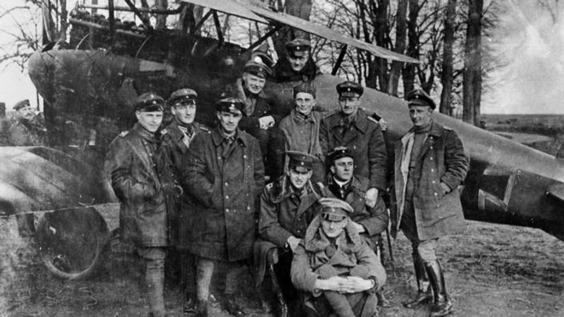 Richthofen in the cockpit of his famous Rotes Flugzeug ("Red Aircraft") with other members of Jasta 11, including his brother Lothar (sitting, front), 23 April 1917.