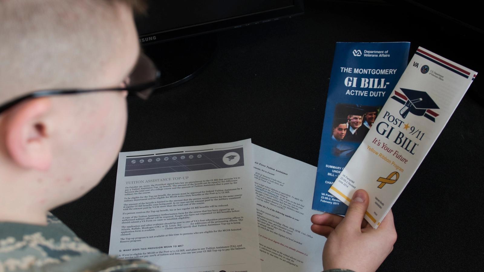 Soldier reads GI Bill brochures.