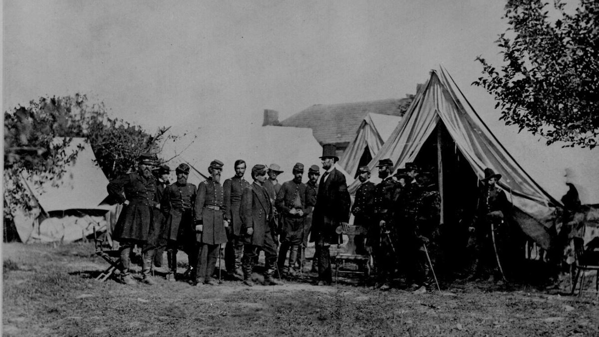 Union soldiers and officers standing outside tents during the Civil War encampment.