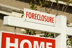 Close-up of Foreclosure sign in front of a house.