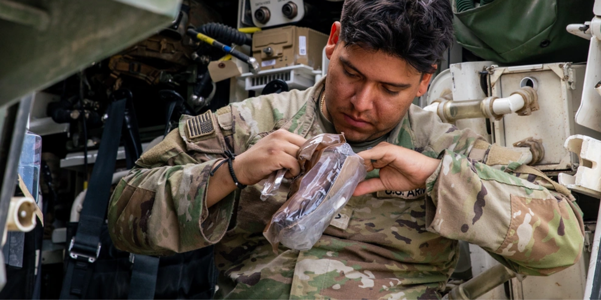 U.S. Army Pfc. Juan Ospinal, an infantryman with the 2nd Cavalry Regiment, opens an MRE after returning from a mission, during Saber Junction 25, at the Joint Multinational Readiness Center's Hohenfels Training Area, Germany, Sept. 9, 2025.