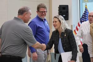 Rep Kiggans shakes hands at a military visit.