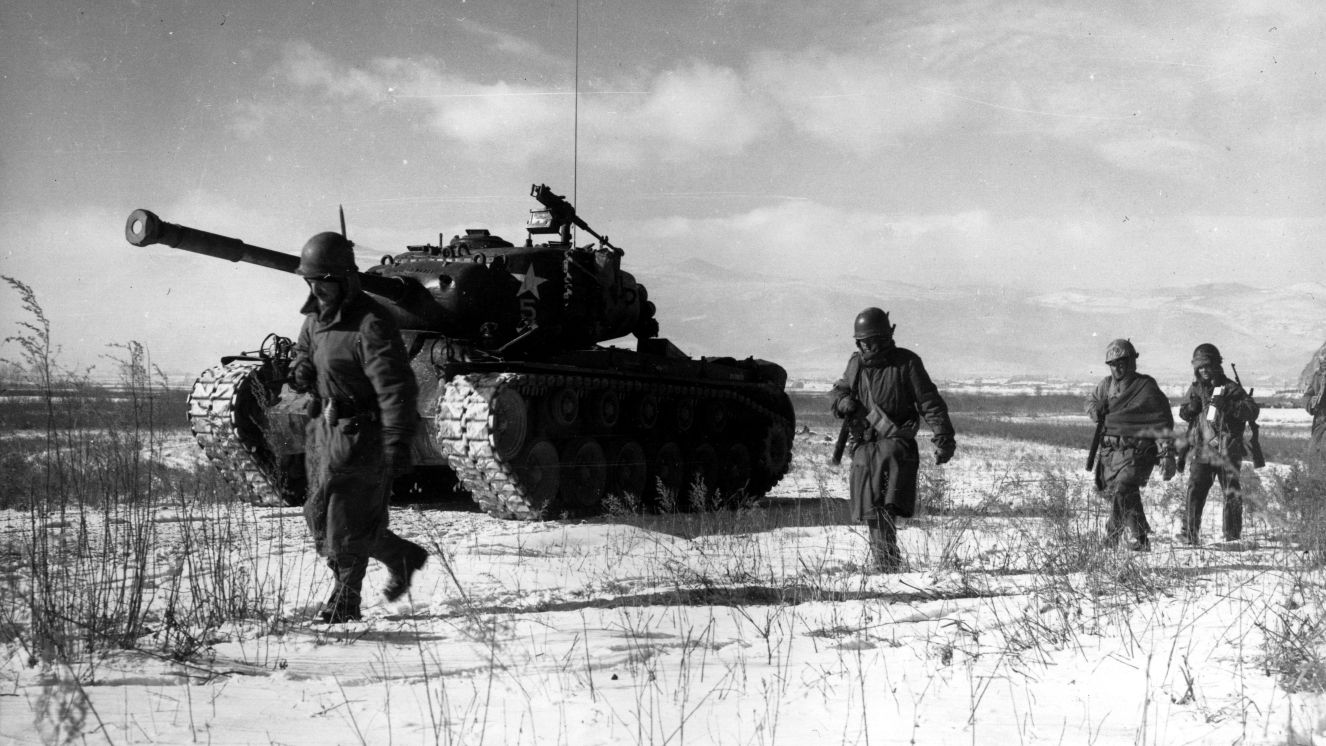 A column of troops and armor of the 1st Marine Division move through Chinese lines during their successful breakout from the Chosin Reservoir in North Korea.