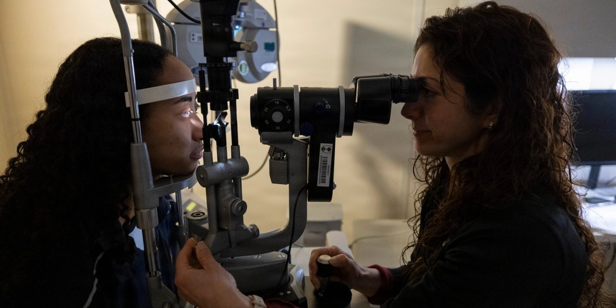 A doctor and patient perform an eye exam.