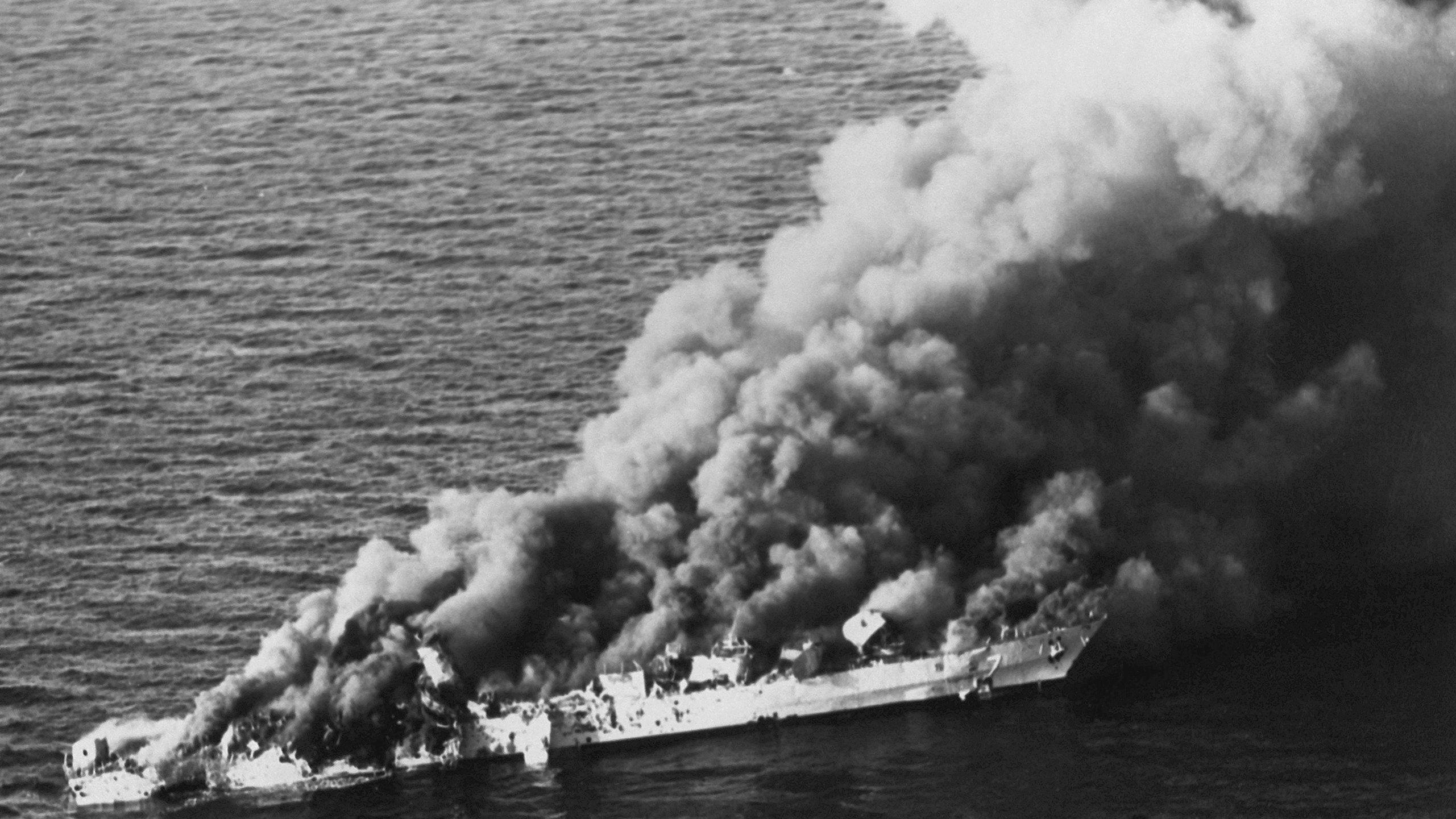 Black and white photo of a burning Iranian frigate.