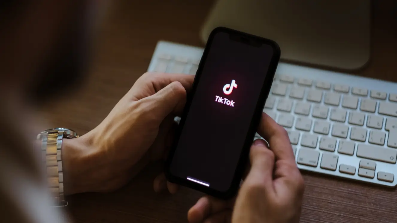 TikTok on iPhone, shown in hand.