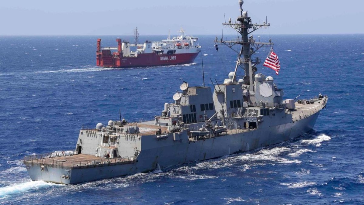 USS Arleigh Burke-class destroyer sailing in Red Sea with cargo ship in background