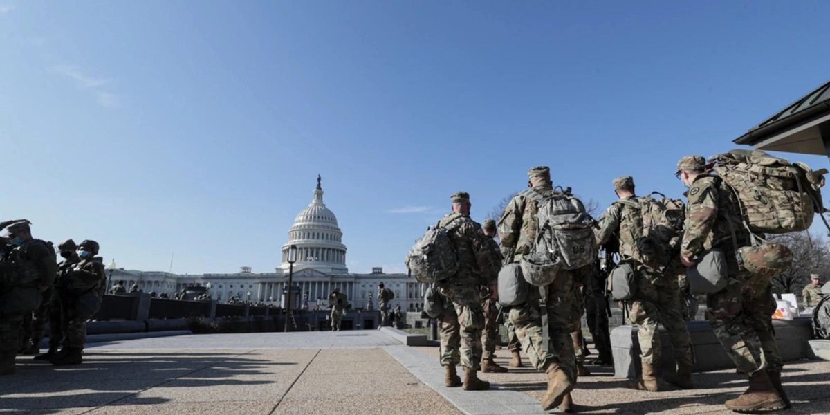 Washington National Guard soldiers with gear near the U.S. Capitol building.