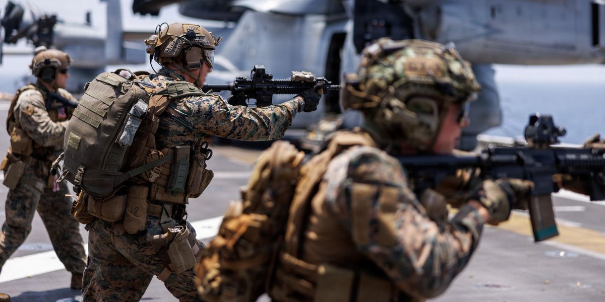 Three soldiers point machine guns.