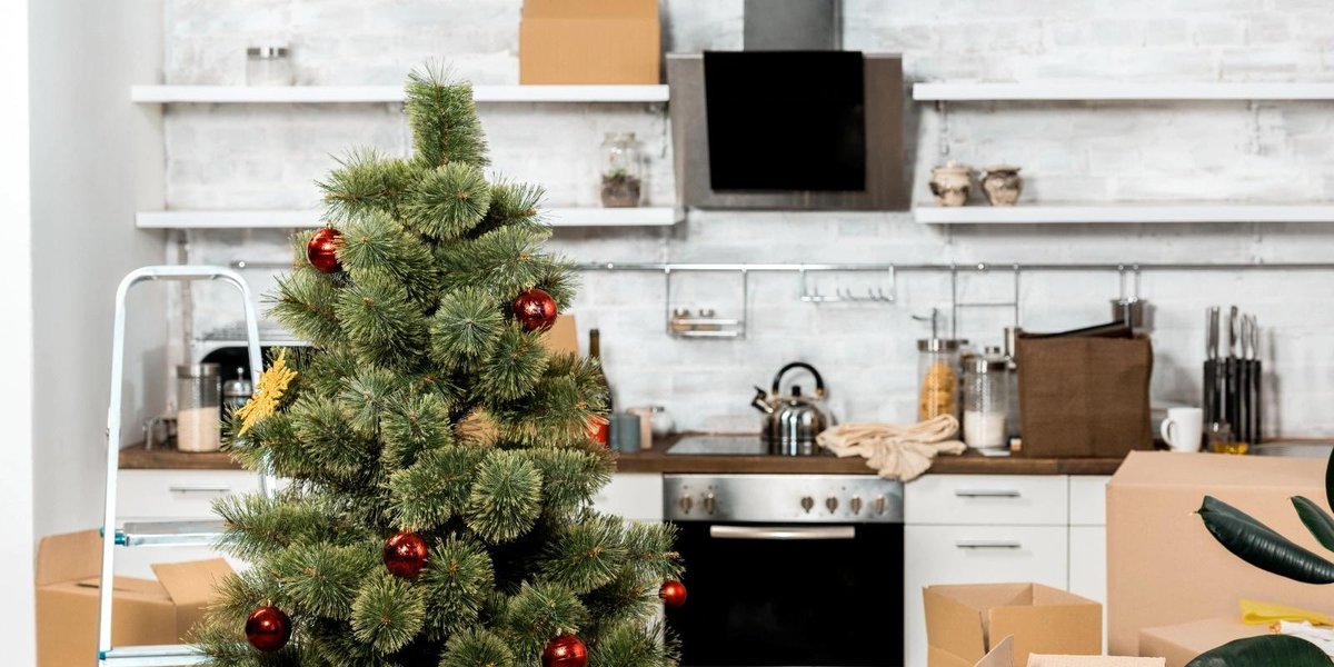 Packed boxes and a decorated Christmas tree in a kitchen, symbolizing a military family's December move.
