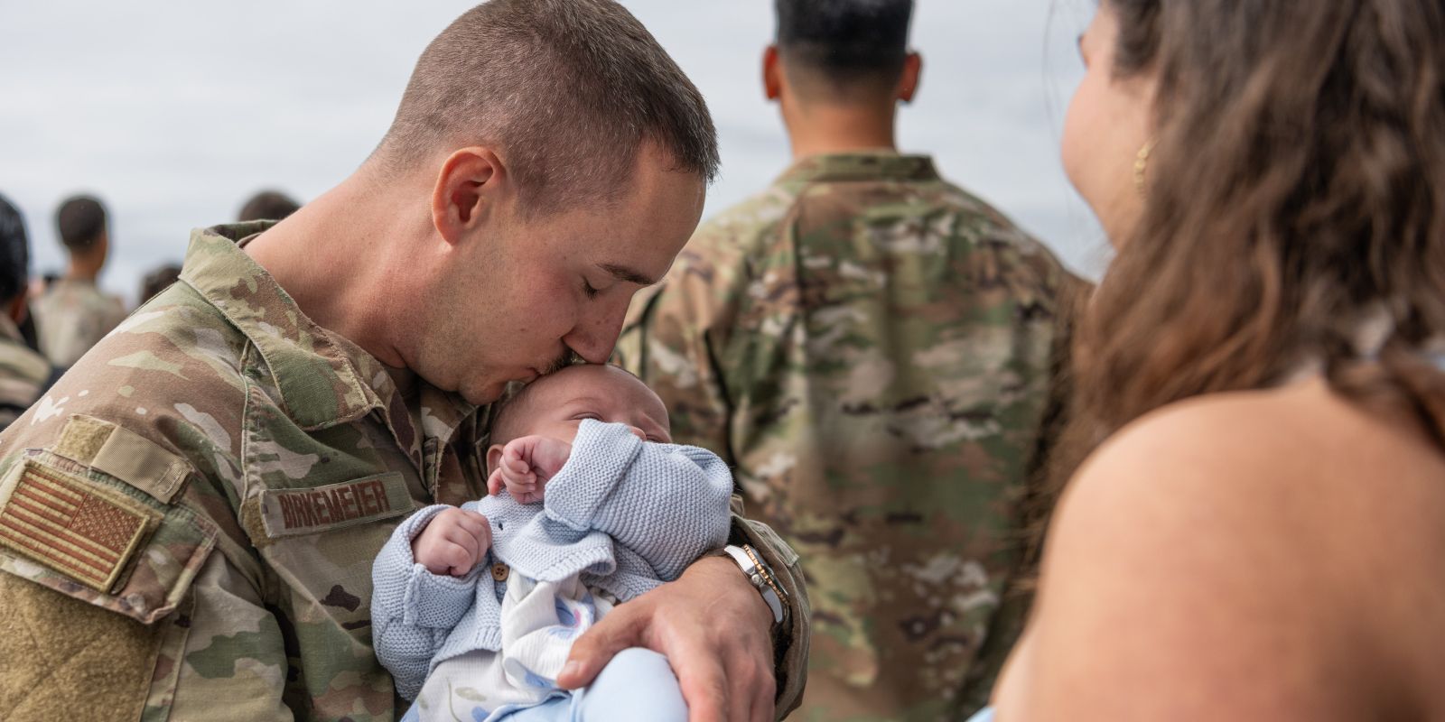 U.S. Air Force Tech. Sgt. Kenneth Birkemeier, 480th Fighter Generation Squadron specialist expediter, kisses his newborn baby for the first time during a redeployment at Spangdahlem Air Base, Germany.