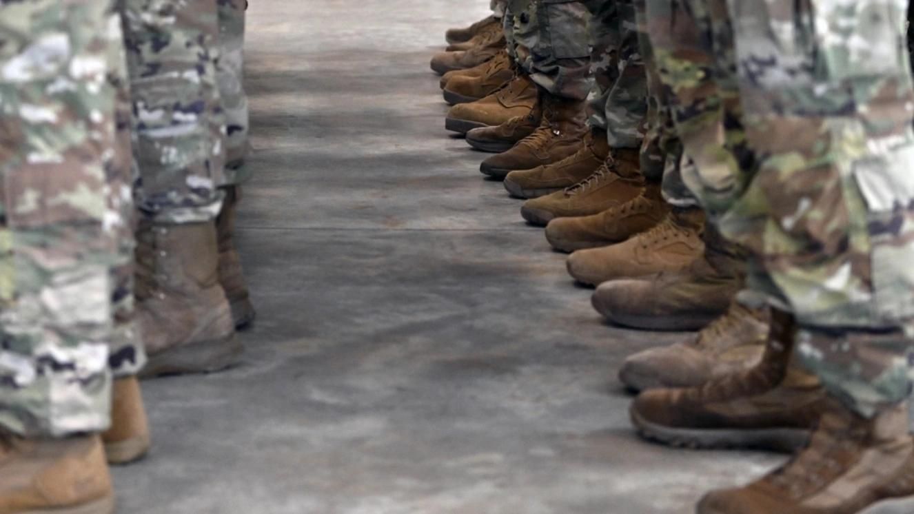 Army soldiers standing in formation wearing camouflage uniforms and boots