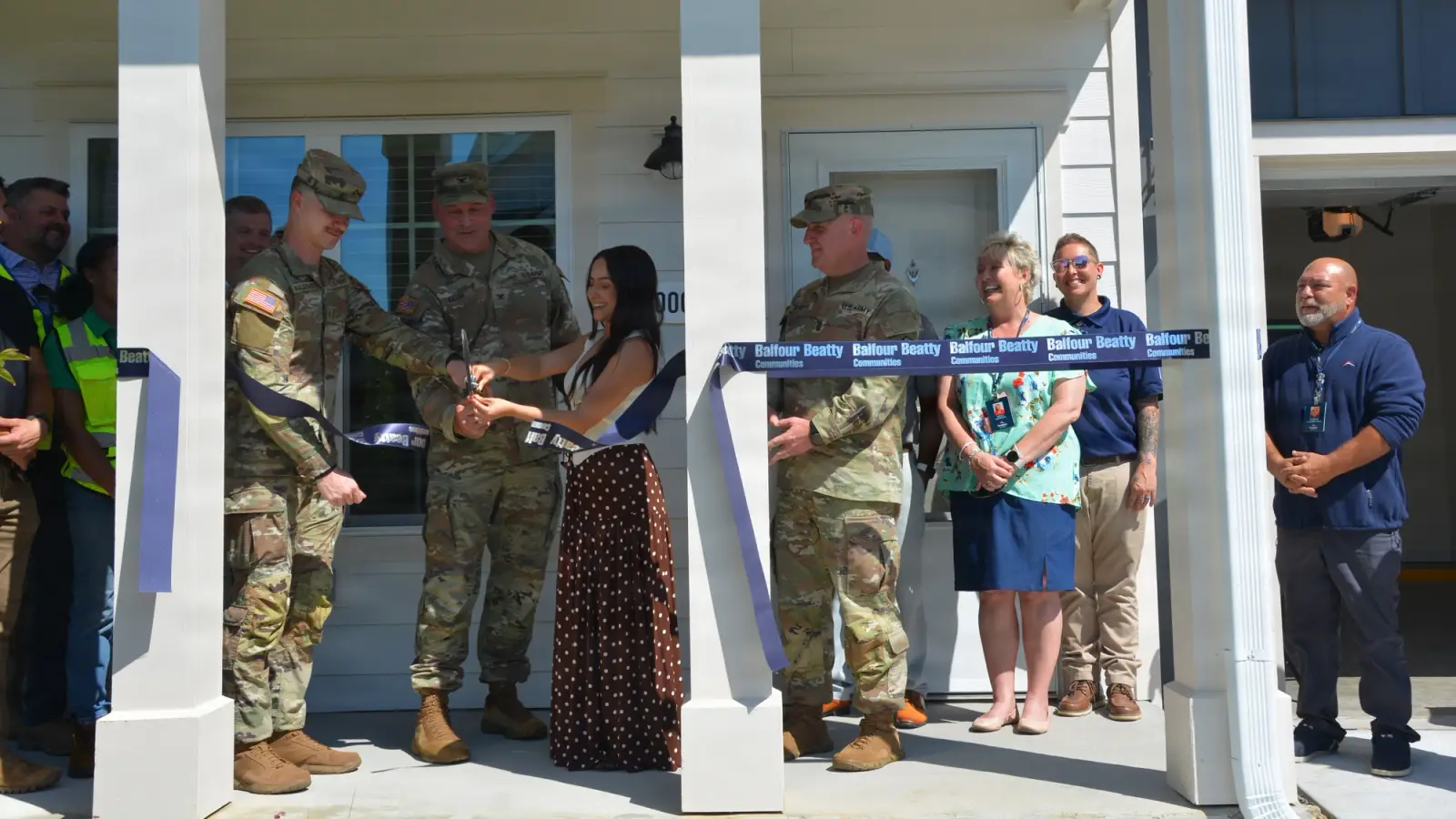 Ribbon-cutting of new housing by soldiers and families.
