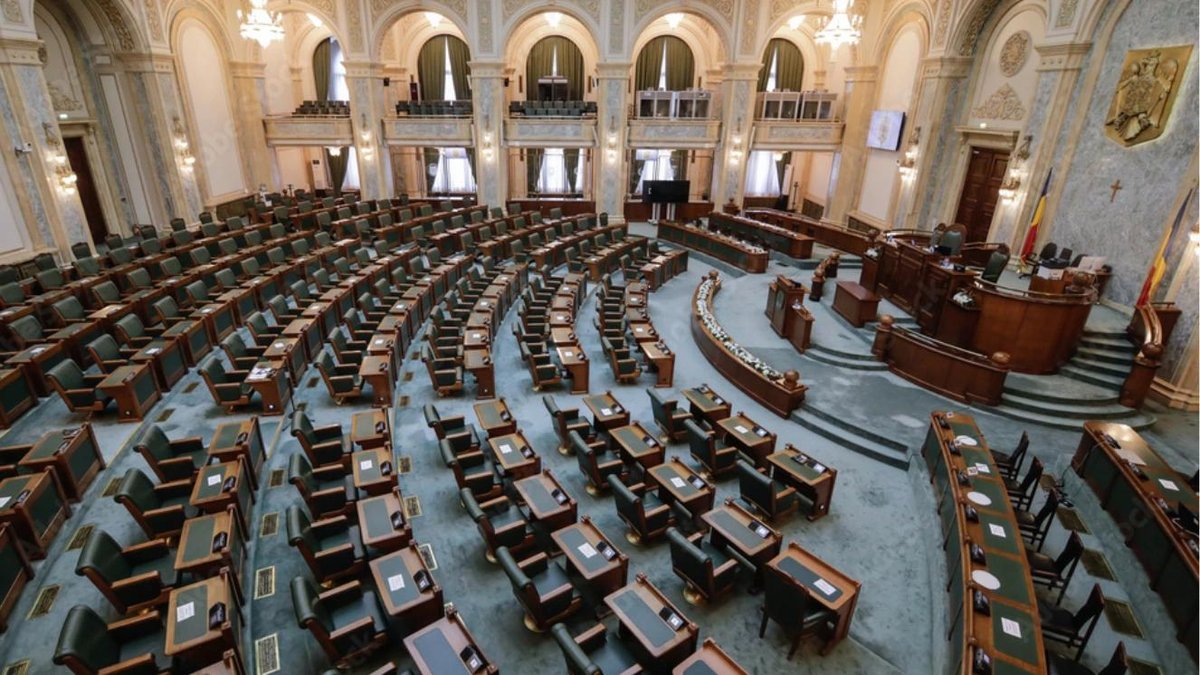 Congress chamber with empty seats arranged in rows, ornate architecture, and American flag displayed.