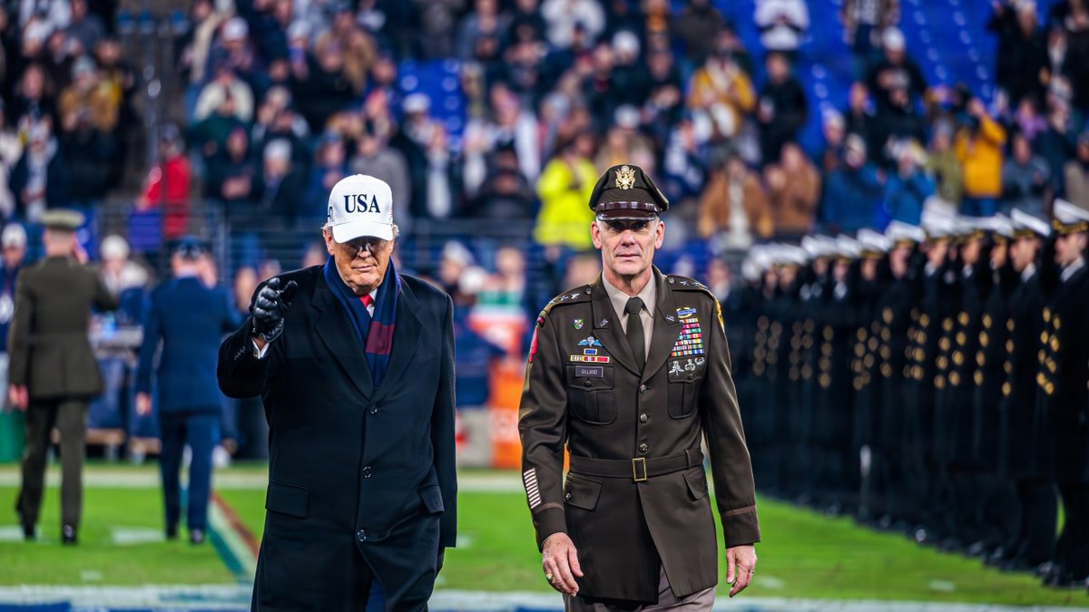 President Trump and an Army Lieutenant walk on a football field.