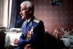 Petrov, in uniform, looks out of a window.