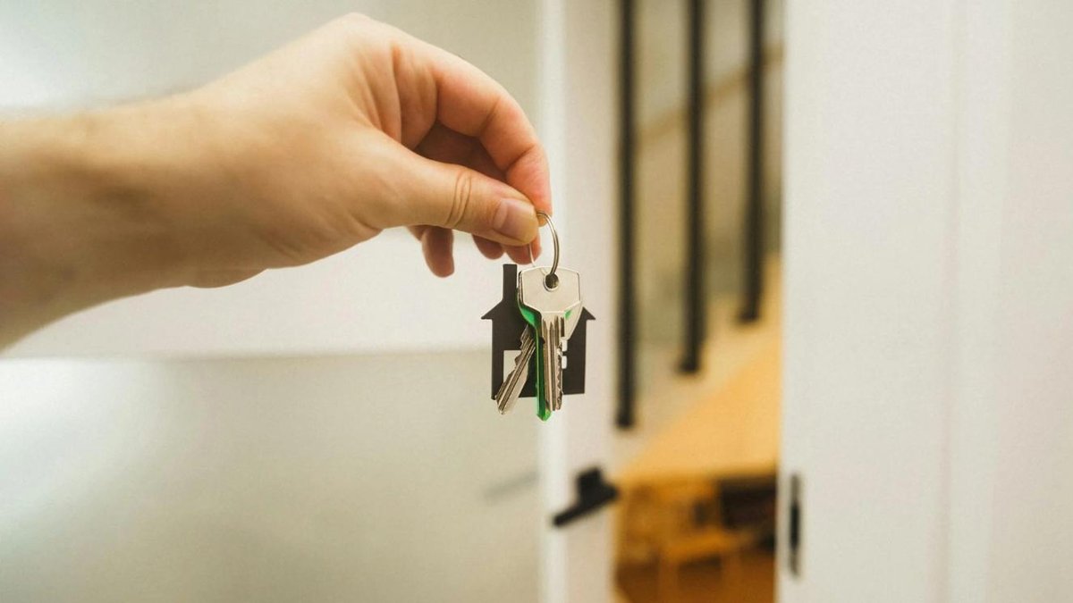 Hand holding house keys inside a home, symbolizing VA mortgage opportunities.