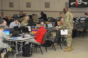 Civilians and reservists work in a cybertraining class.
