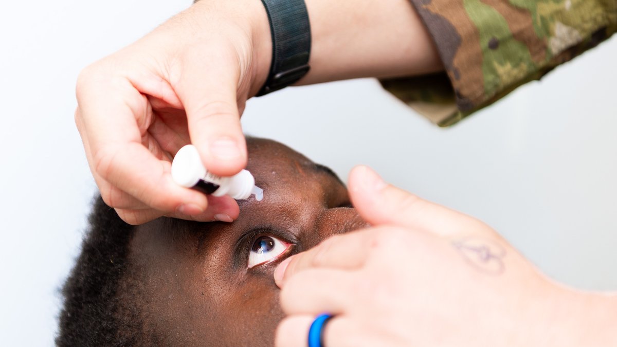 Airman demonstrates receiving medical eye drops.
