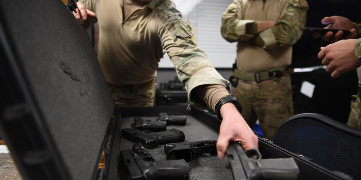 Three soldiers are handling guns during a training session.