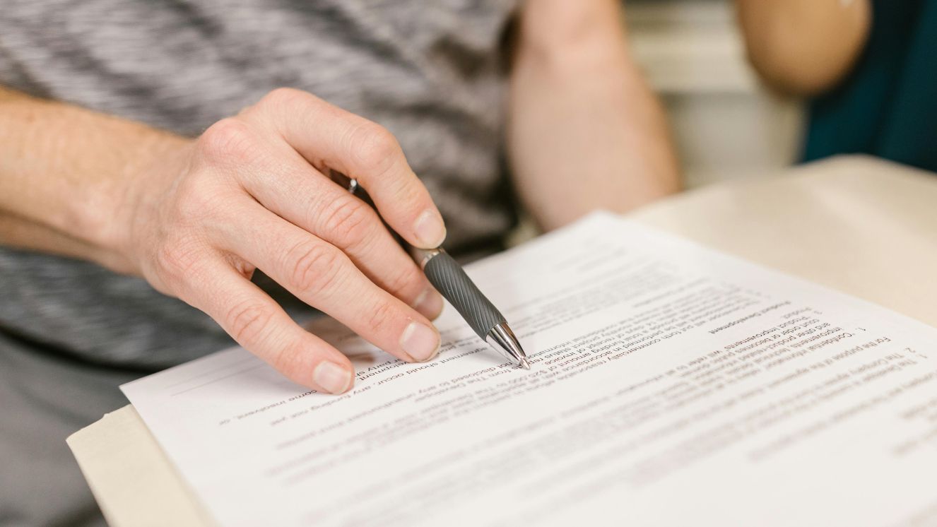 A person writing on white paper.