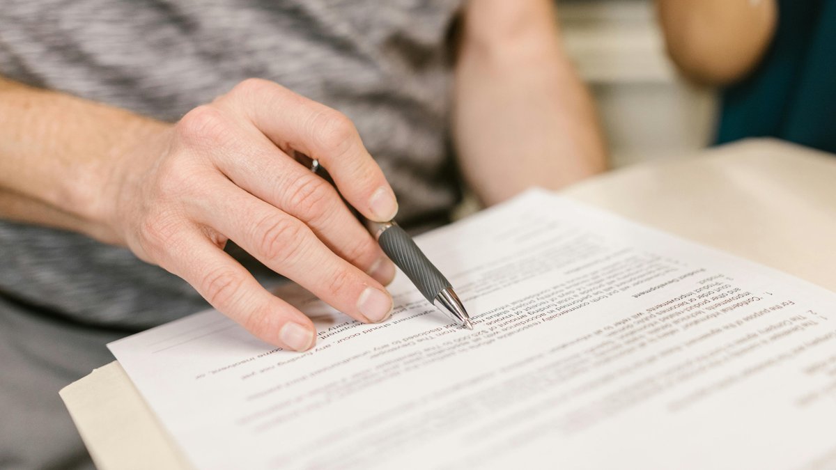 A person writing on white paper.