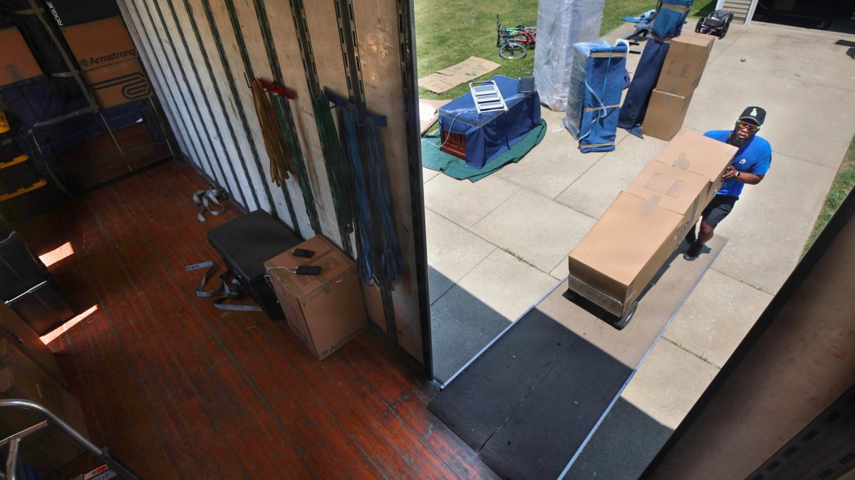 Mover rolls boxes onto a truck.
