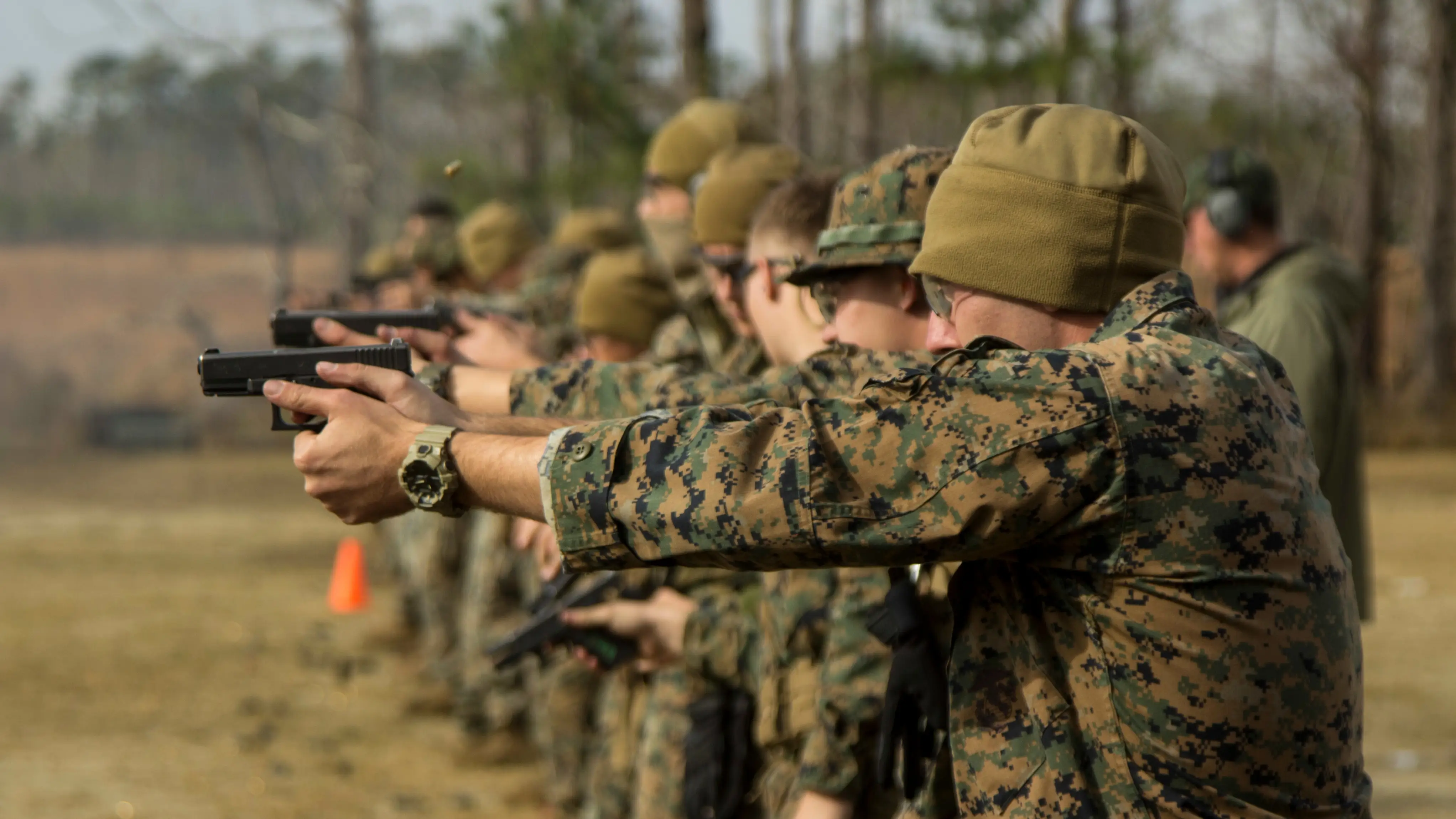 A row of young service people during target practice.