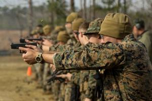 A row of young service people during target practice.